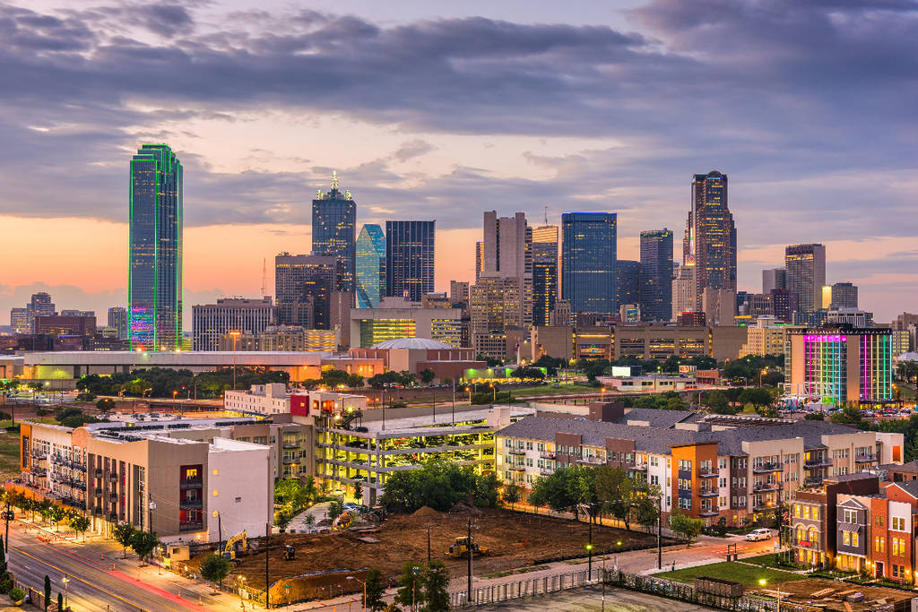 Image shows Dallas skyline under an overcast sky.