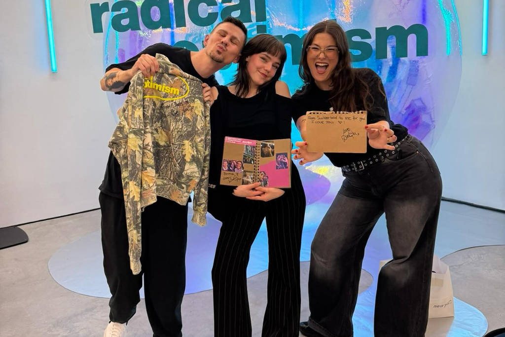 Image shows fans posing with merchandise at the Dua Lipa 'Radical Optimism' pop-up.