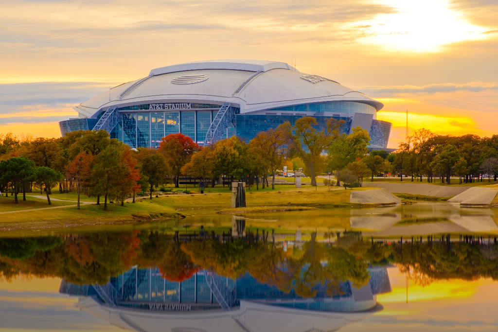Image shows AT&T Stadium surrounded by fall foliage.