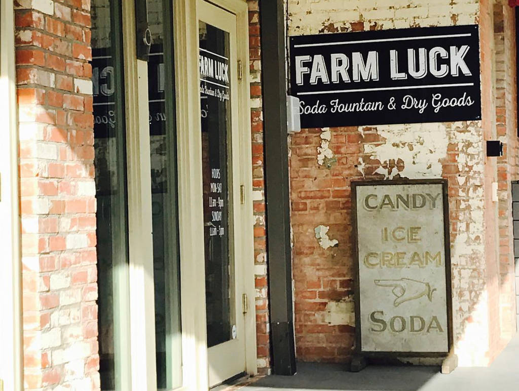 Image shows the entrance to Farm Luck soda fountain and dry good store in Waxahachie, Texas.