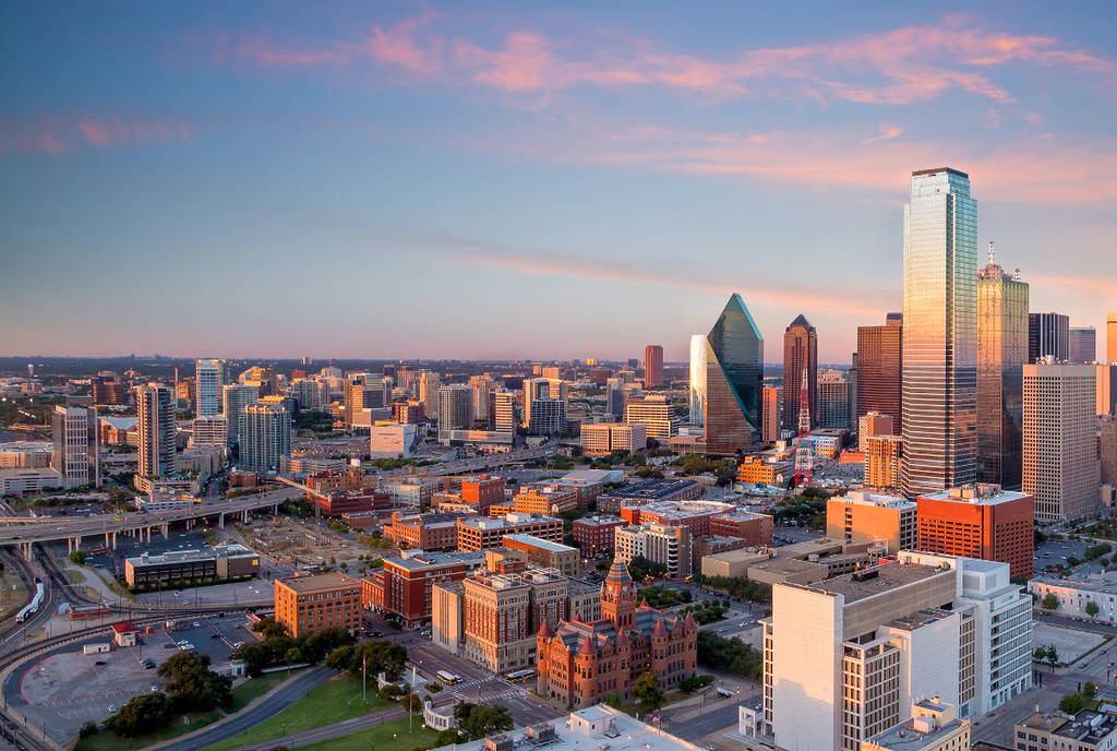 Image shows a landscape shot of the Dallas city during sunset.