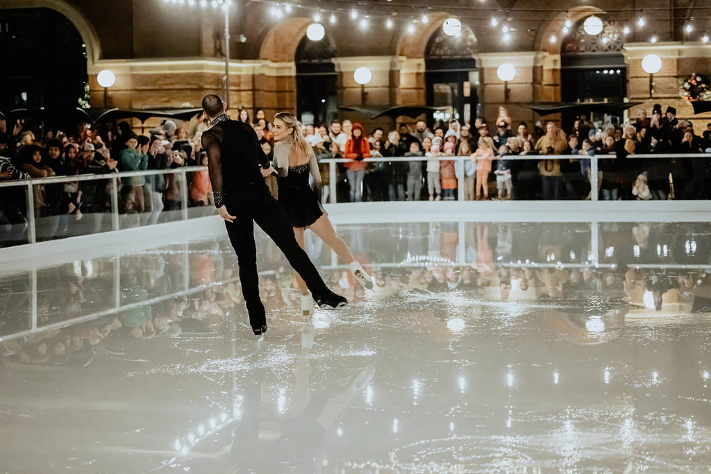 Image shows a figure skating duo performing at the Peace Plaza Ice Rink in Grapevine, Texas.