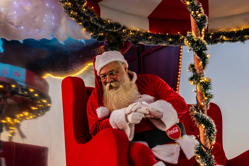 Image shows Santa Claus leaning over in his chair.
