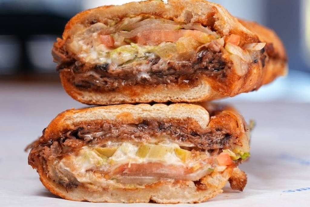 Image shows the brisket sub halved and stacked on top of each other from Snarf's.