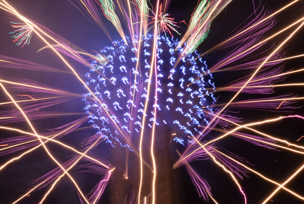 Image shows a close up of the Reunion Tower surrounded by fireworks.