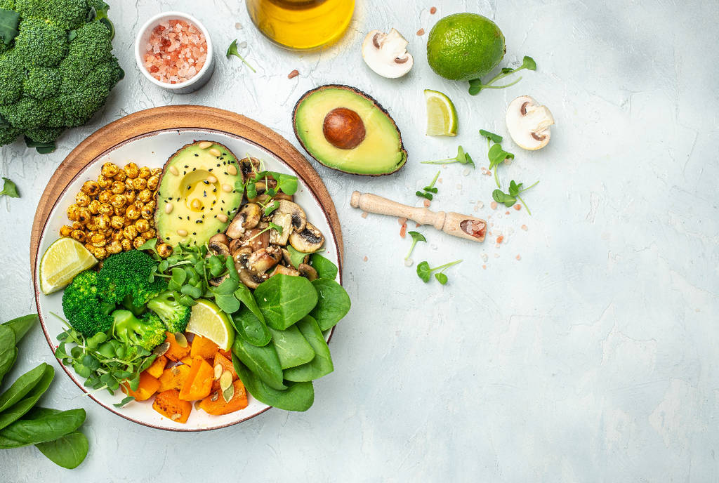 Image shows a salad with a scattering of vegetables next to the bowl.