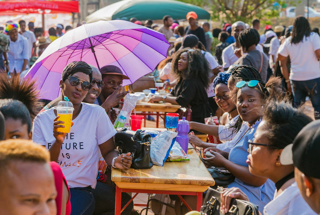 Image shows a group of people dining outside at a farmers market.
