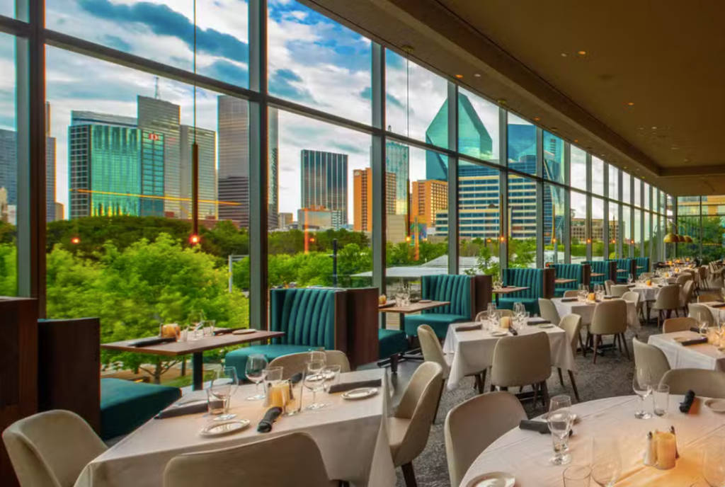 Image shows the interior of Perry's Steakhouse Grille in Dallas with large windows overlooking Downtown Dallas.