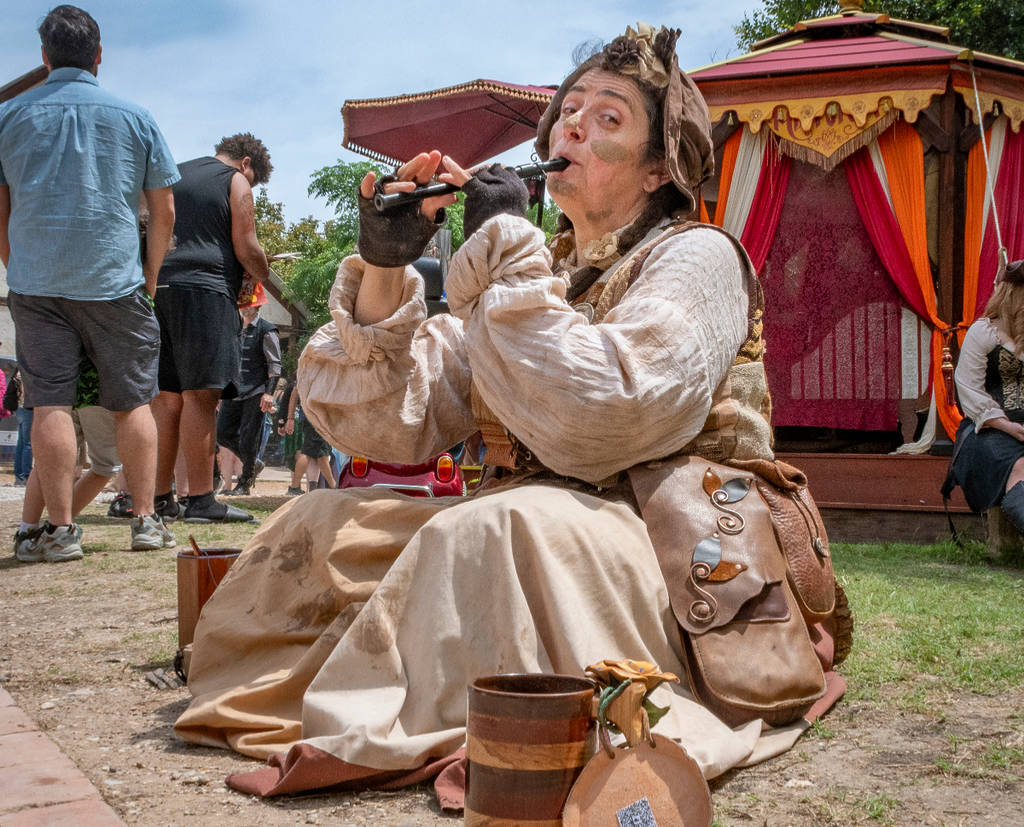Image shows a woman in 16th-century clothing playing a wind instrument.