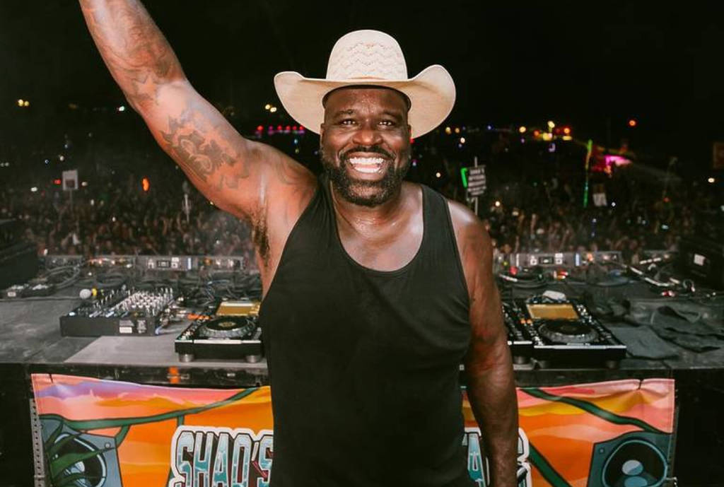 Image shows Shaquille O' Neal in a cowboy hat posing on stage at Shaq's Bass All-Stars Festival.