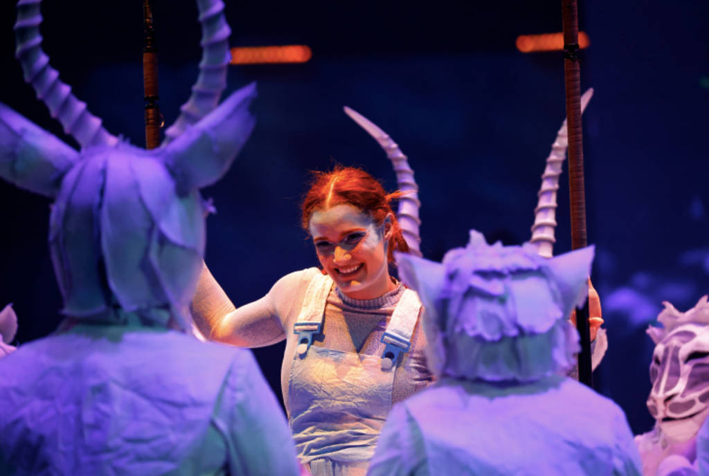 Image shows a woman performing among other costumed actors during the performance of "ECHO" by Cirque du Soleil.