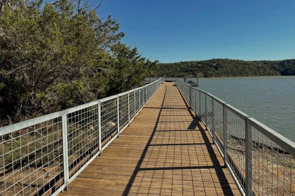 Image shows a walkway at a Palo Pinto Mountains State Park lake. 