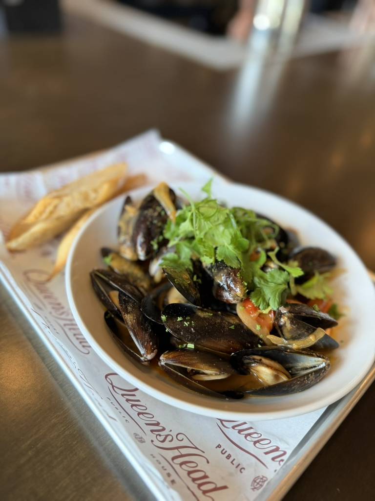 La imagen muestra un plato de mejillones al curry. 