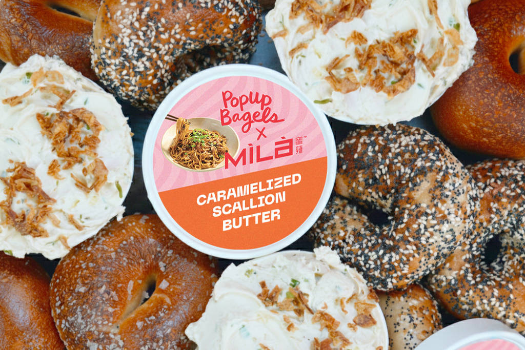 Image shows a selection of bagels with a caramelized scallion butter schmear centered with the "mila" name featured.
