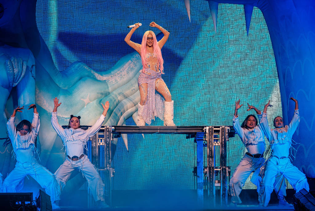 Image shows Karol G performing on stage.