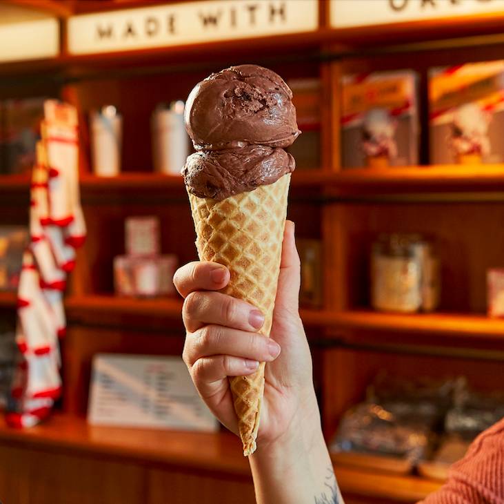 La imagen muestra a una persona sosteniendo un cono de helado de Salt & Straw.