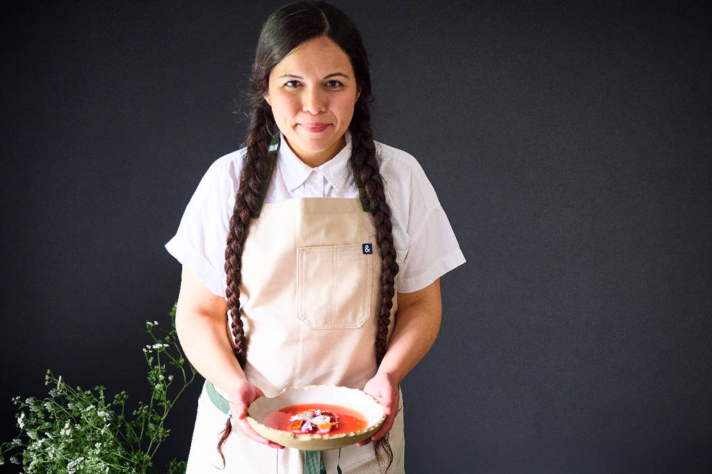 La imagen muestra a la chef Olivia López sosteniendo un plato.