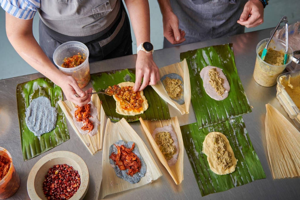 Image shows chefs preparing traditional Mexican food.