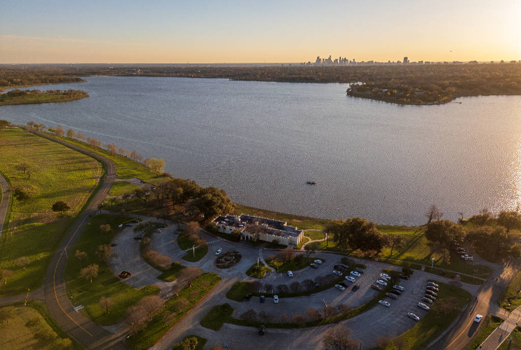 Image shows White Rock Lake with the Dallas skyline in the background.