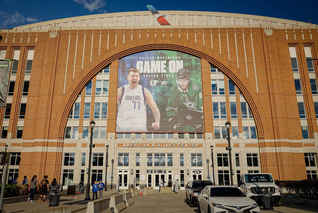 La imagen muestra la fachada del American Airlines Center en Dallas con publicidad de los Dallas Stars y los Dallas Mavericks.