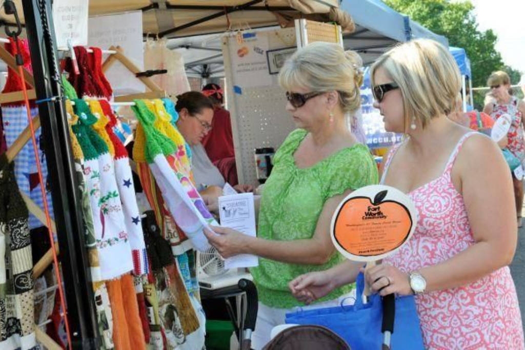 Image shows two people browsing at the Parker Count Peach Festival. 