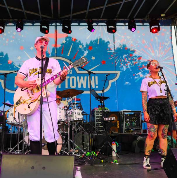 La imagen muestra a unos músicos tocando en el escenario de Addison Kaboom Town!