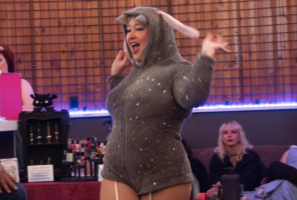 La imagen muestra a una bailarina de burlesque vestida con un traje de «Burro», inspirado en Shrek. 