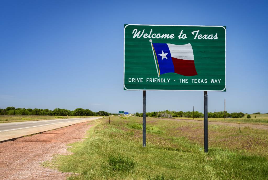 La imagen muestra una señal de carretera que dice «Bienvenido a Texas»