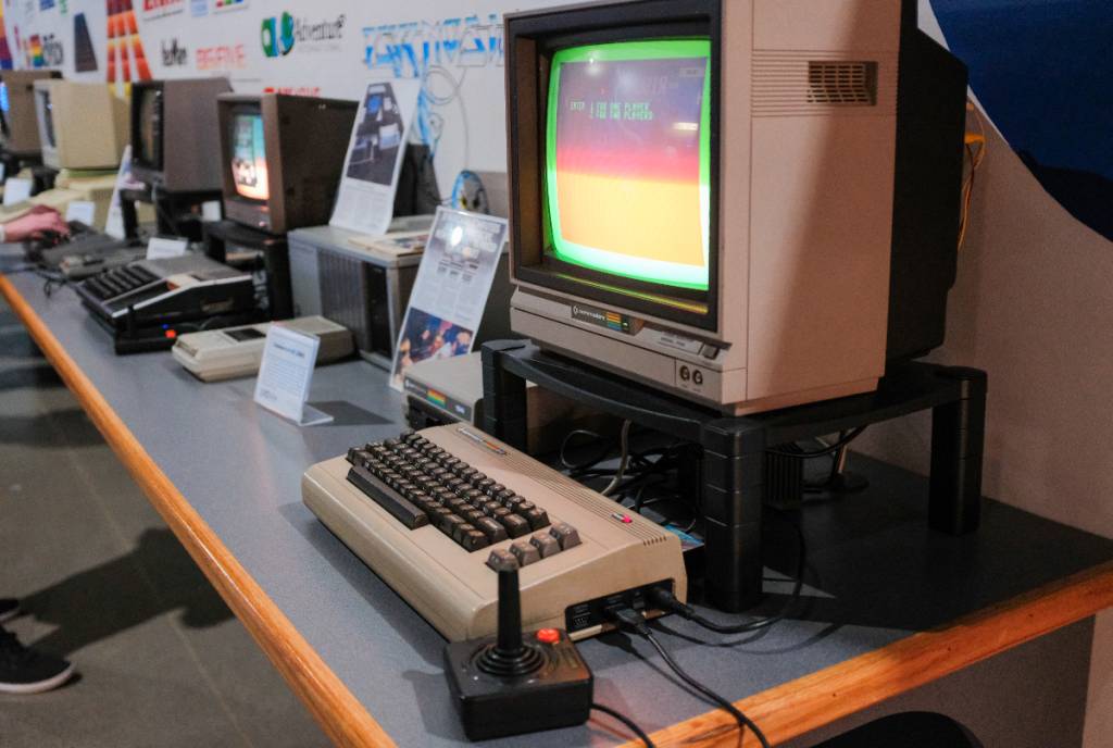 La imagen muestra una fila de consolas de videojuegos de estilo retro.