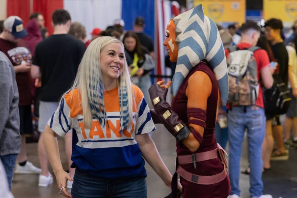 La imagen muestra a un actor de doblaje y a un cosplayer en la FAN EXPO Dallas.