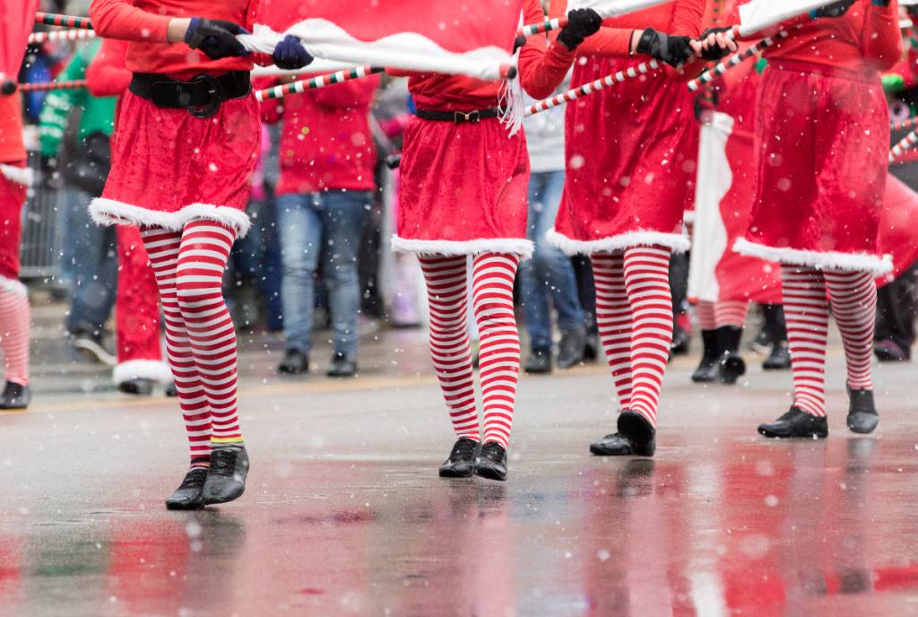 La imagen muestra a bailarines navideños durante una actuación en un desfile.