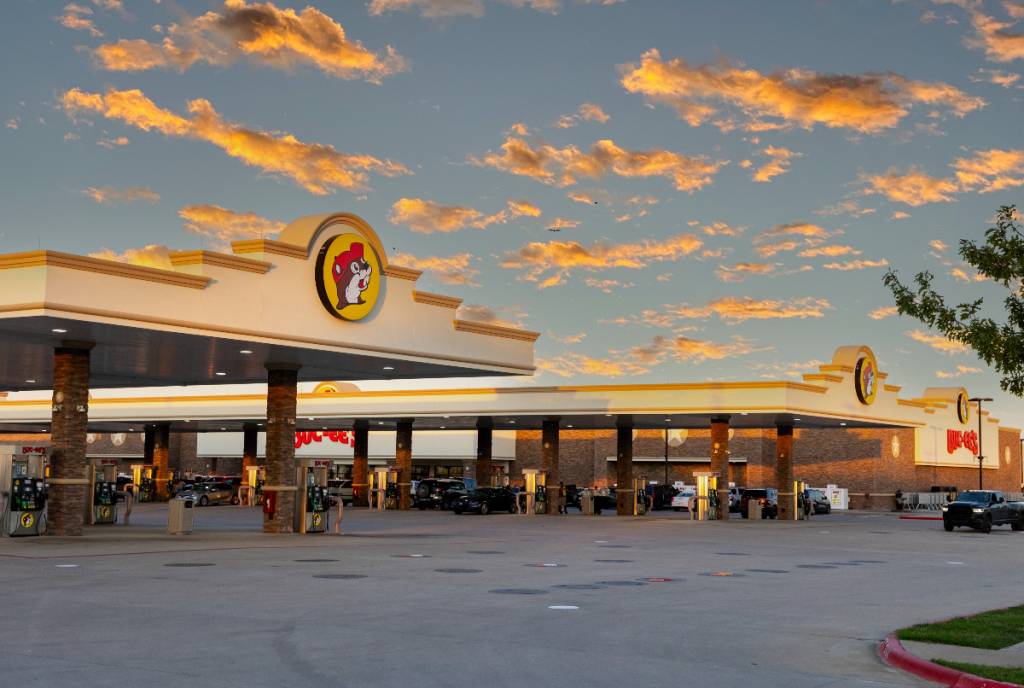 La imagen muestra una gasolinera Buc-cee’s al atardecer.