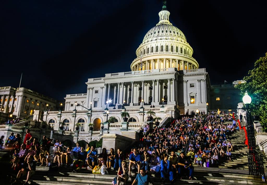 View of the Capitol and people sitting on its steps at Memorial Day concert at night