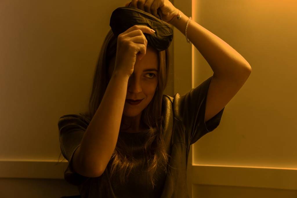 A woman putting on a blindfold at Dining in the Dark