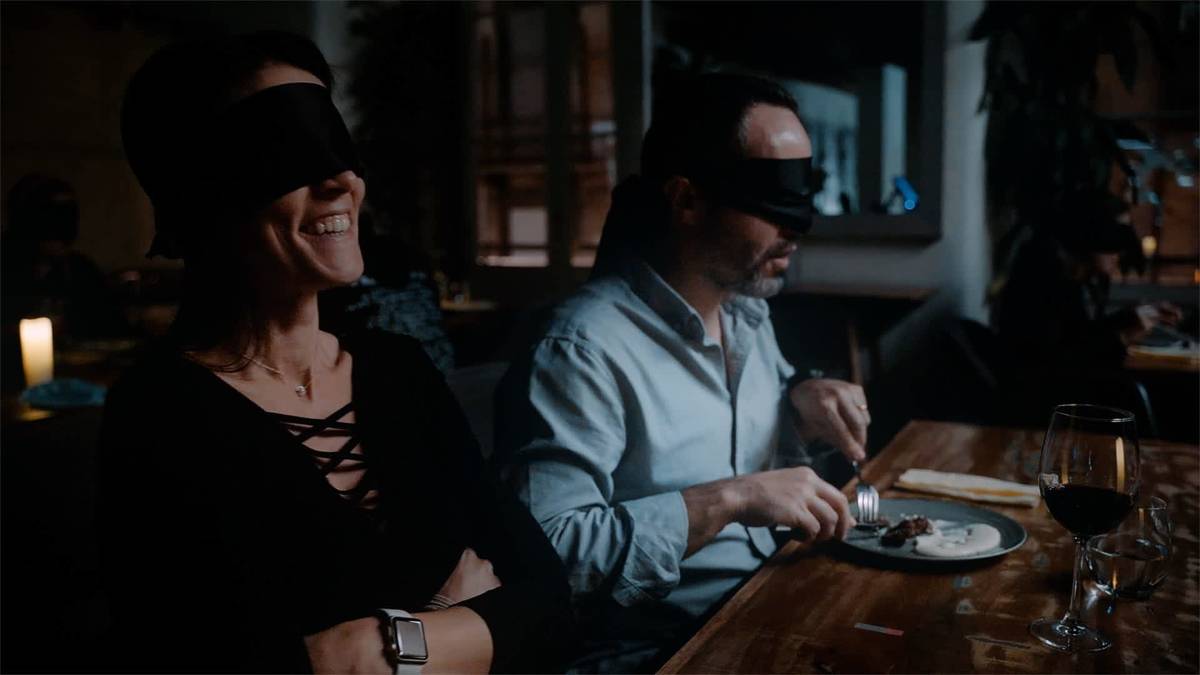 Two men zith blindfolds on in a Dining in the dark event