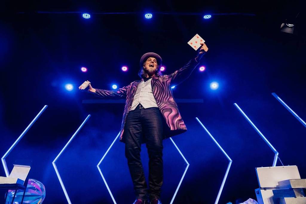 A magician performing card tricks on stage