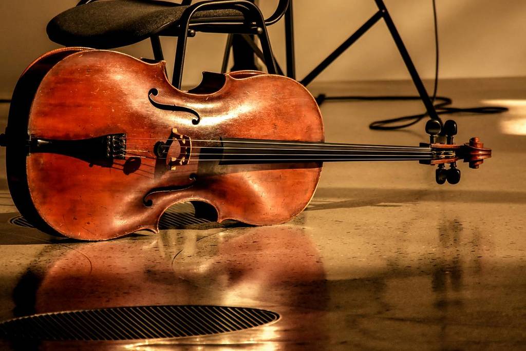 A violin lays horizontally on the floor.