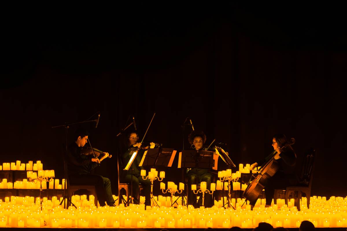 A string quartet performing amid a sea of candles
