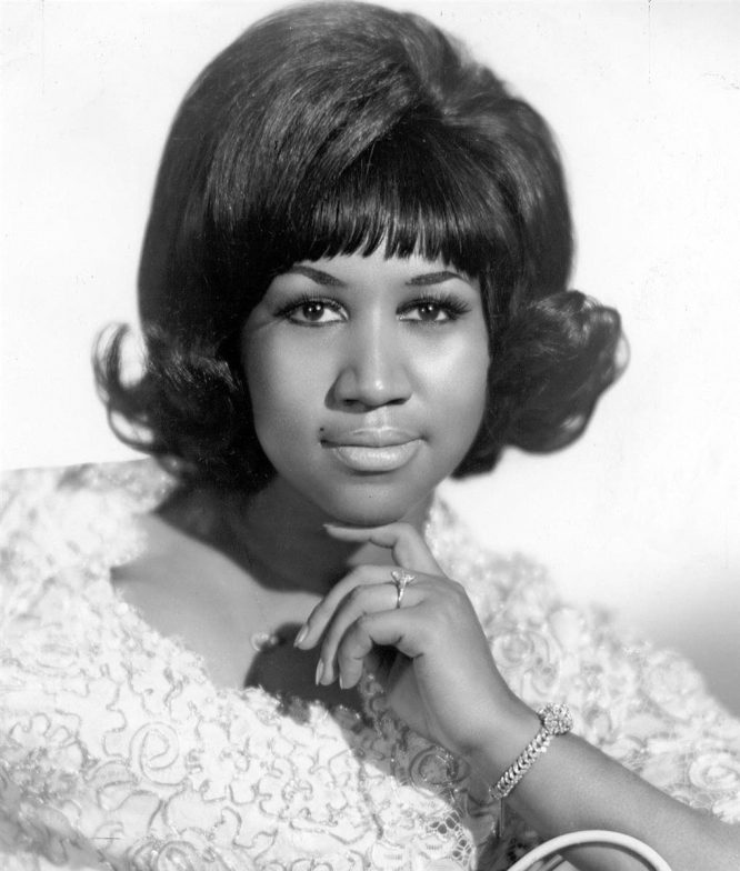 A black and white photo of Aretha Franklin as a young woman.