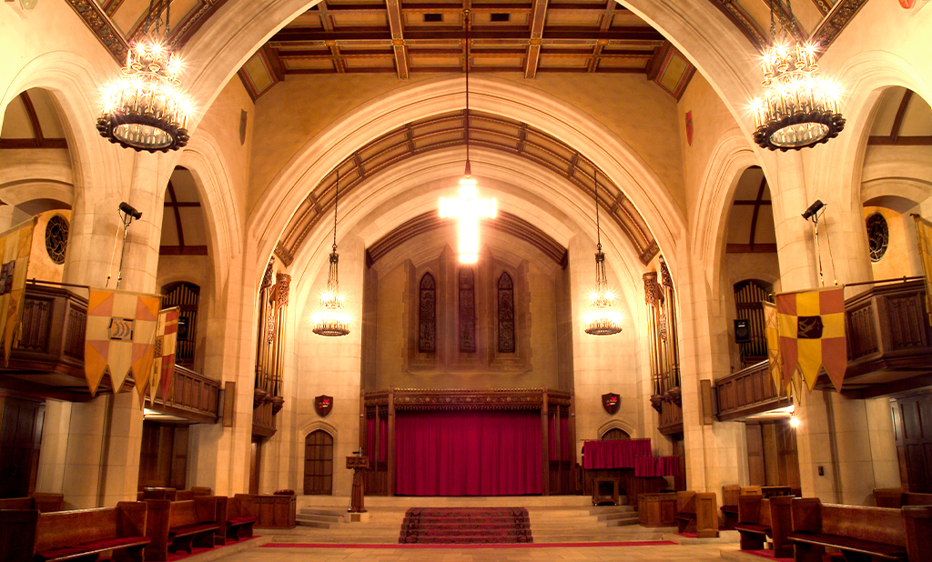The grand interior of the Detroit Masonic Temple with a glowing cross hanging from the ceiling.