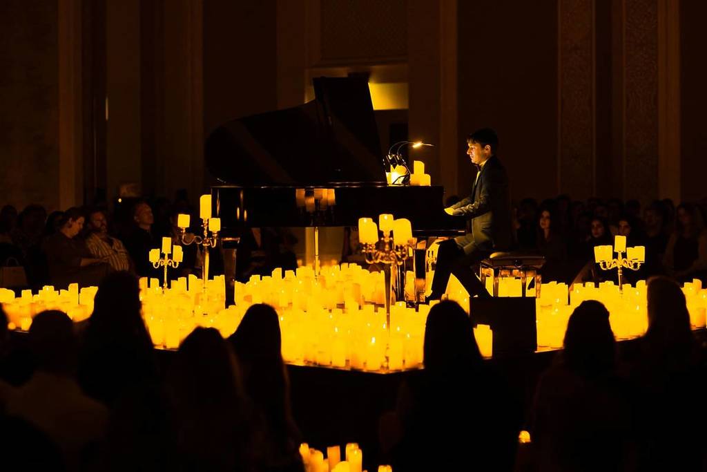 Un pianista actúa entre un mar de velas en un concierto a la luz de las velas en el Majlis Madina Jumeirah de Dubai