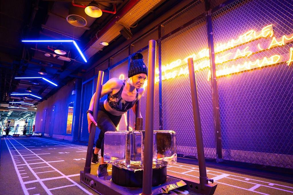 A lady pushing ice blocks on a sled at Gym Nation's coolest class which is one of the best things to do in July in Dubai