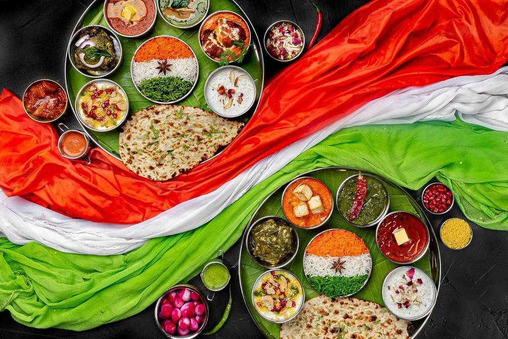 A picture of non-veg and veg thali meals with the indian flag coloured cloth in the middle at Dhaba Lane for Indian Independence Day
