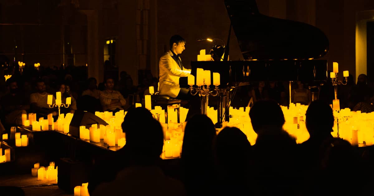 A pianist performing amid a sea of candles