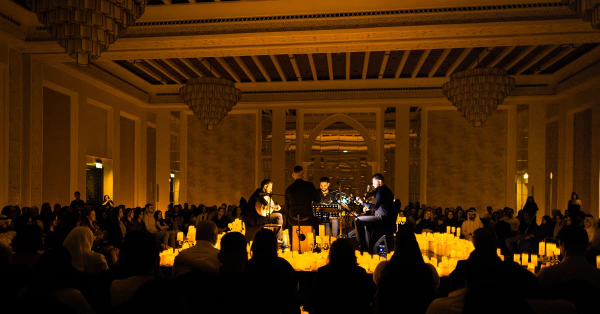 Four musicians performing surrounded by a sea of candles at Al-Majlis Madinat Jumeirah, Mina ASalam