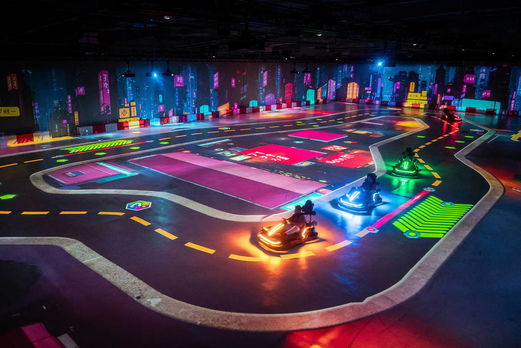 A group of racers racing along the neon glow of Chaos Karts Dubai