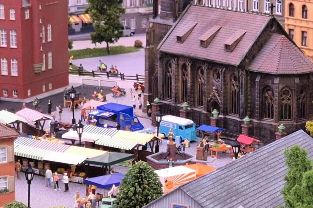 A miniature version of a European town featuring transportation systems, a church and people at Small Worlds Dubai