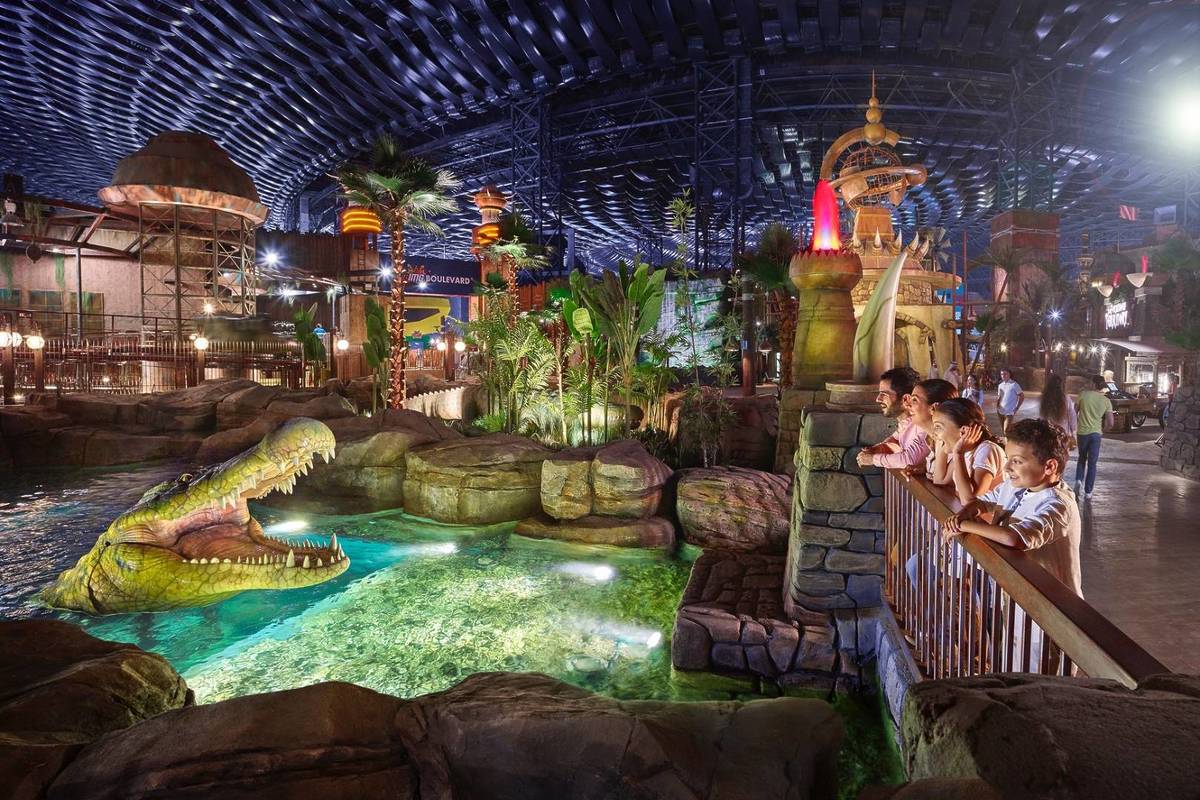 Children at IMG World of adventure admiring an animatronic crocodile in awe