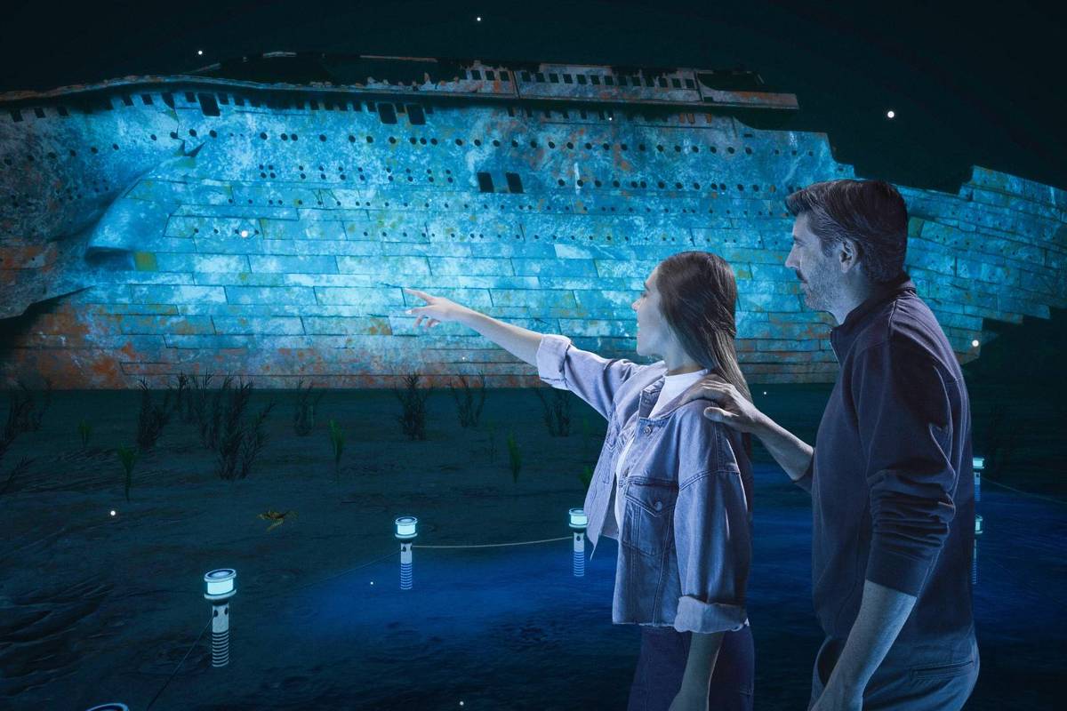 A couple pointing at the wreckage of the Titanic