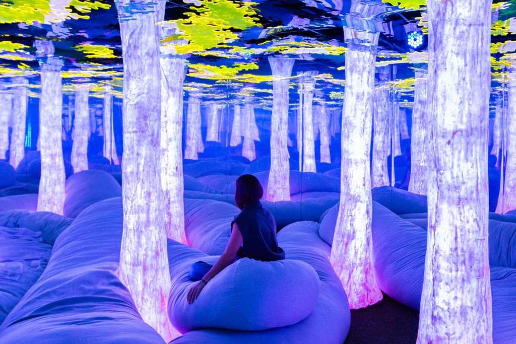 Un visitante de Dopamine Land se relaja en un bosque de suaves cojines y luz en la Euphoria Grove.